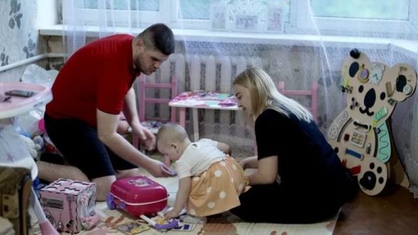 Viktoria com o marido Serhiy e a filha Eva no apartamento em Pokrovsk — Foto: BBC/DAVY MCILVEEN